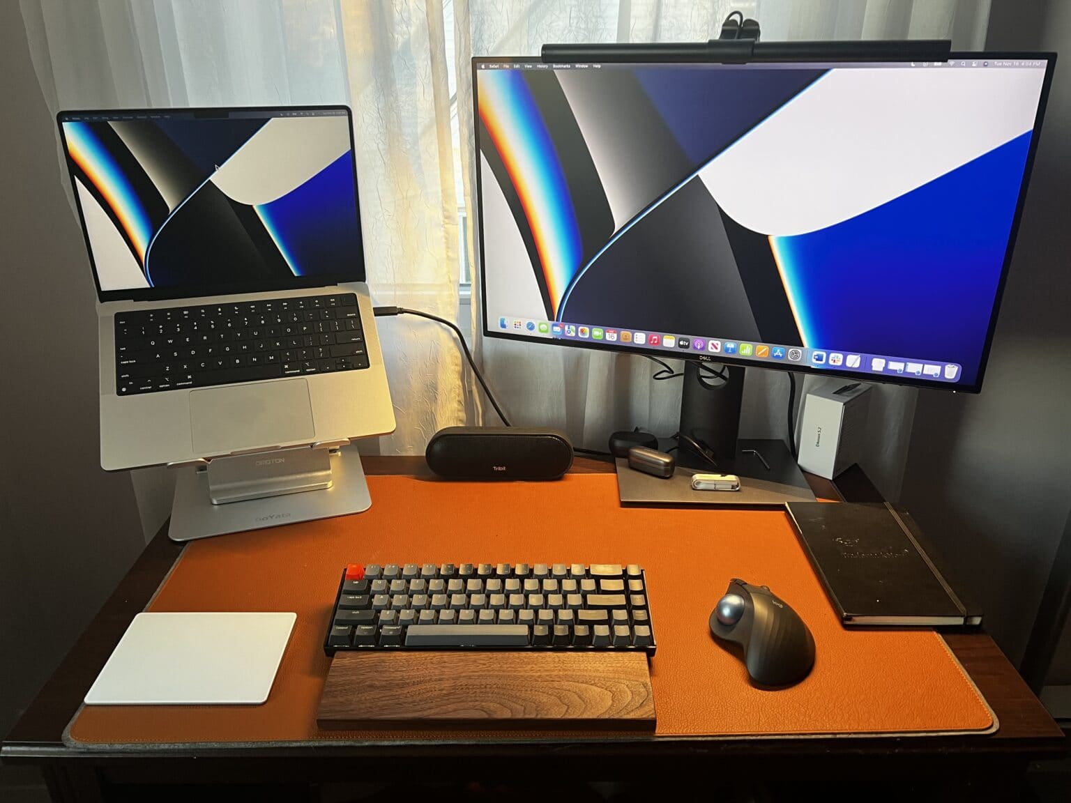 In round 2, I experiment with an open laptop stand, a mechanical keyboard with a wrist rest, a Magic Trackpad 2, an ergonomic mouse with a trackball and a monitor light bar.